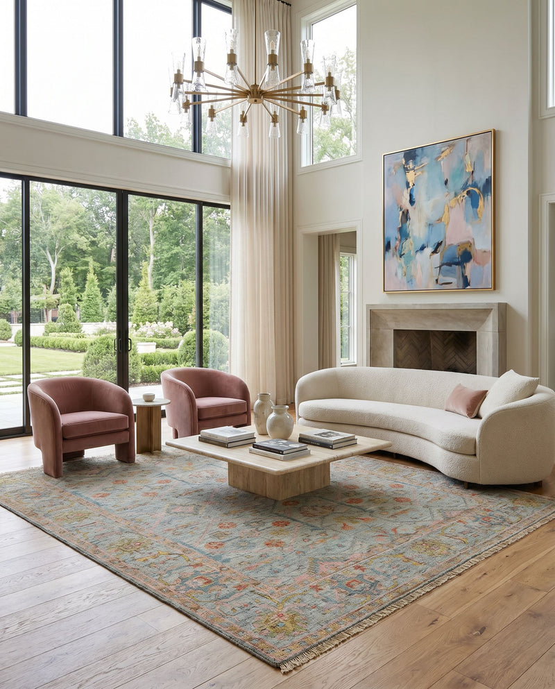 Reign REG-2323 Hand Knotted Rug as the centerpiece of a bright luxury living room — a hand knotted traditional area rug in pale blue, dusty pink, mustard and light brown tones
