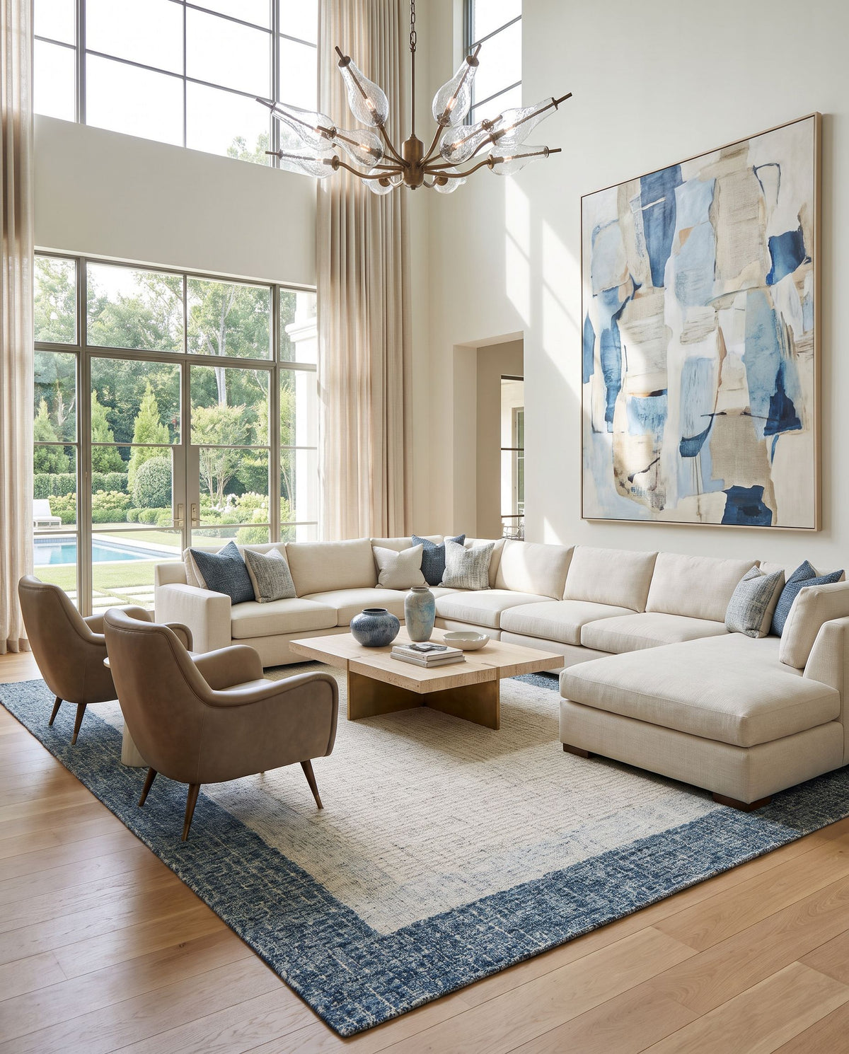Bordighera Hand Tufted Rug as the centerpiece of a bright luxury living room — a hand tufted modern area rug in teal, light gray, medium gray and cream tones